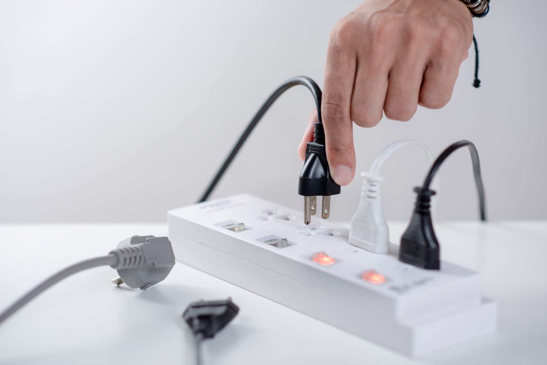 Hand plugging in a cable to a smart power strip