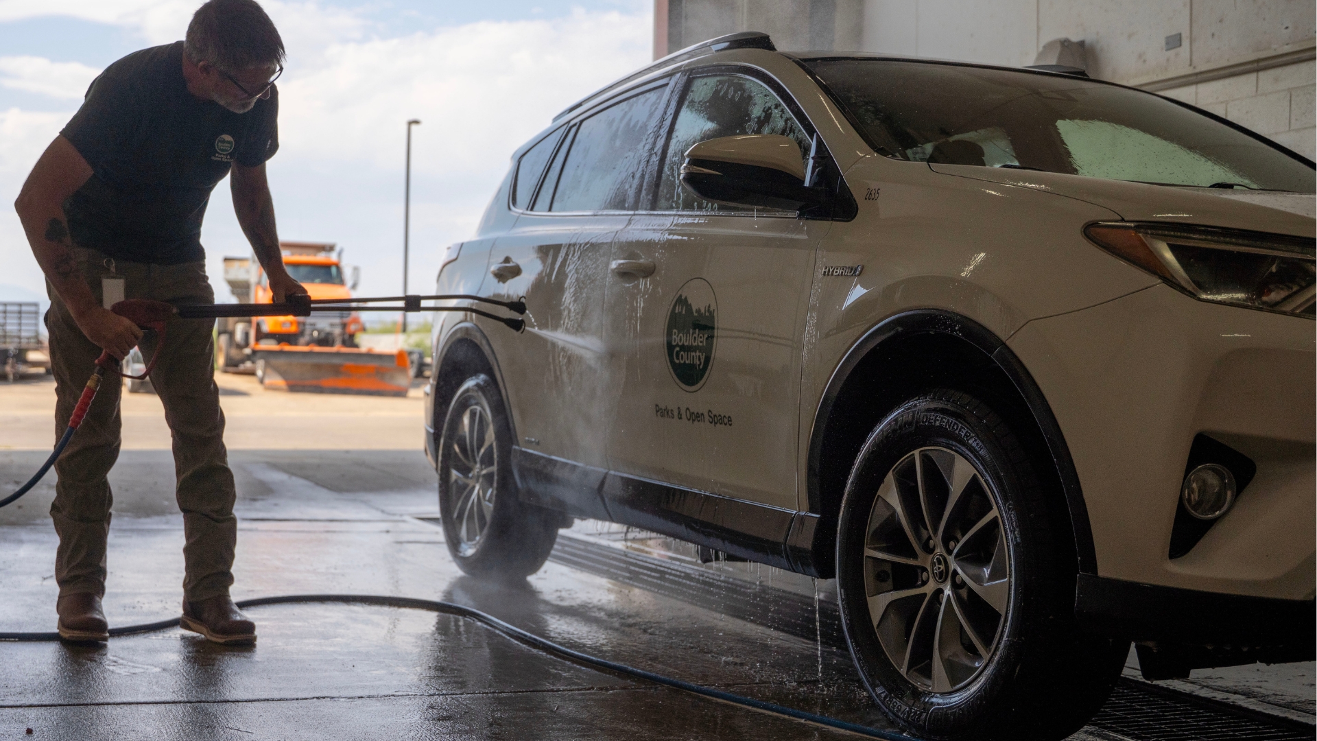A man washes a car inside a commercial car wash
