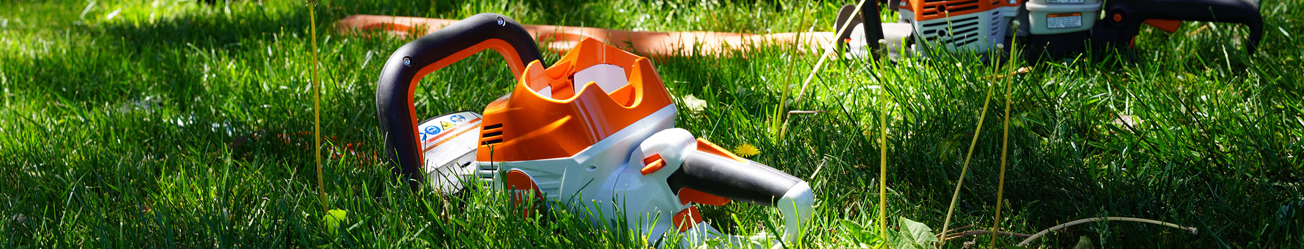 Electric landscaping equipment in grass