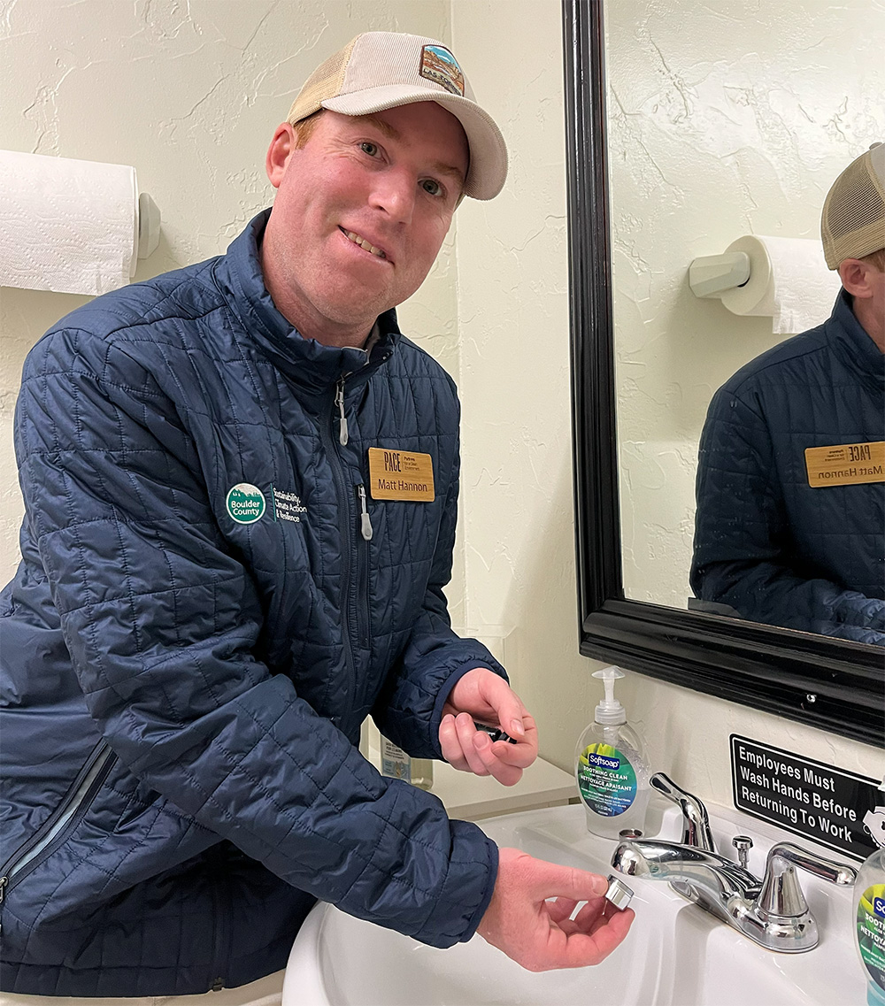 Matt-Water A PACE advisor is installing an aerator on a sink in a local business.