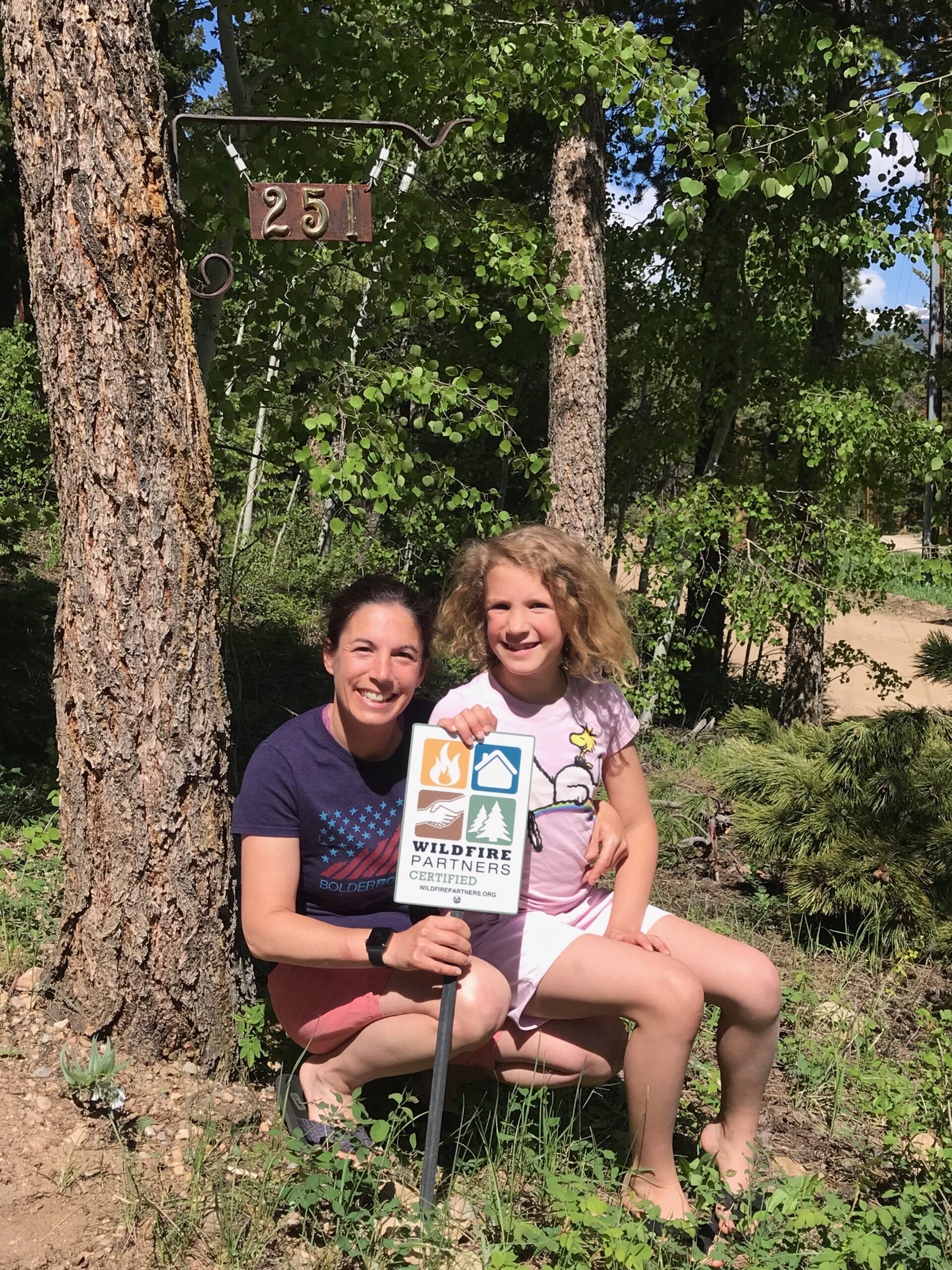 Family proudly displaying their Wildfire Partners yard sign after getting certified