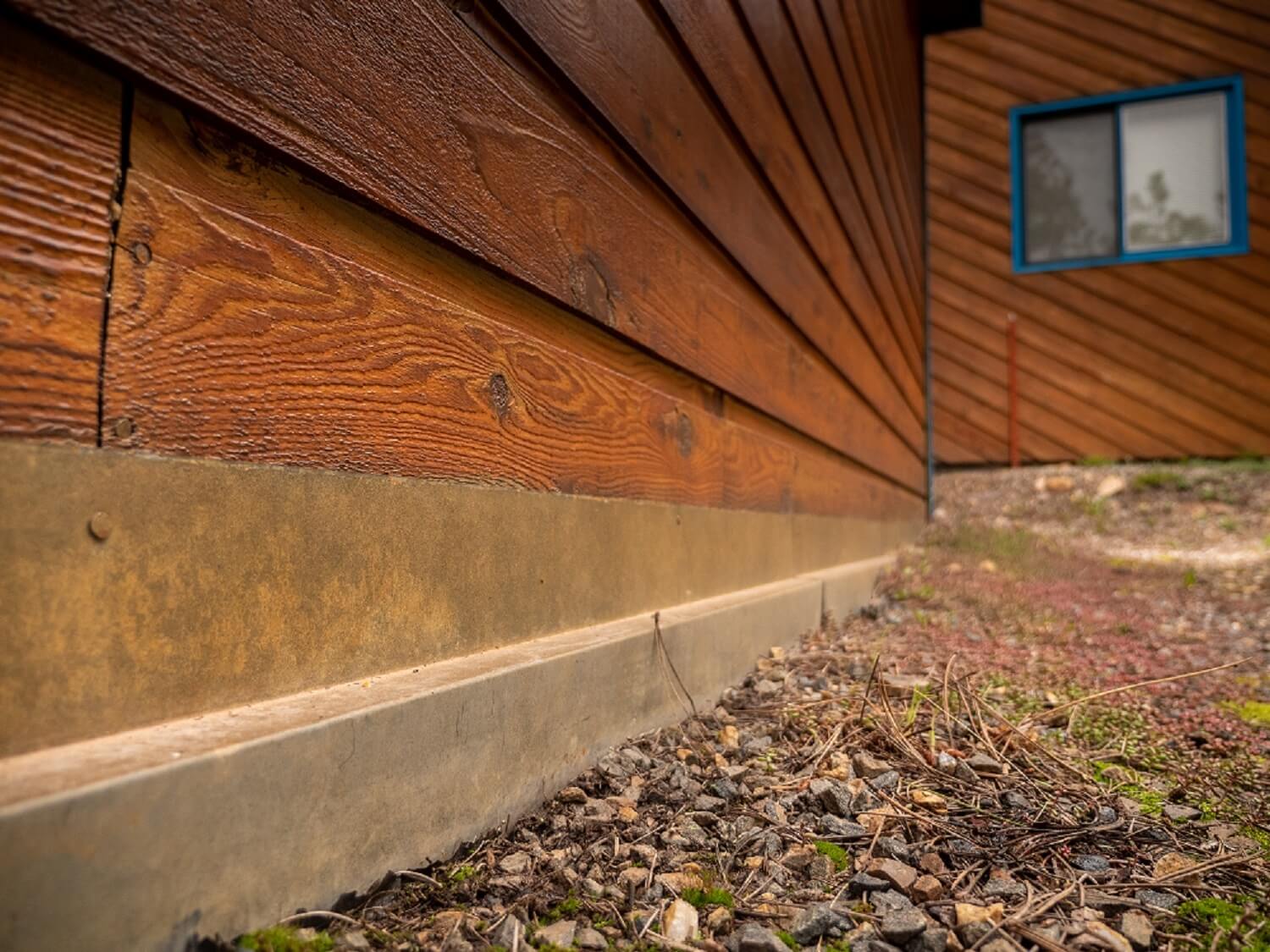 Metal flashing with rust patina blends in with wooden siding