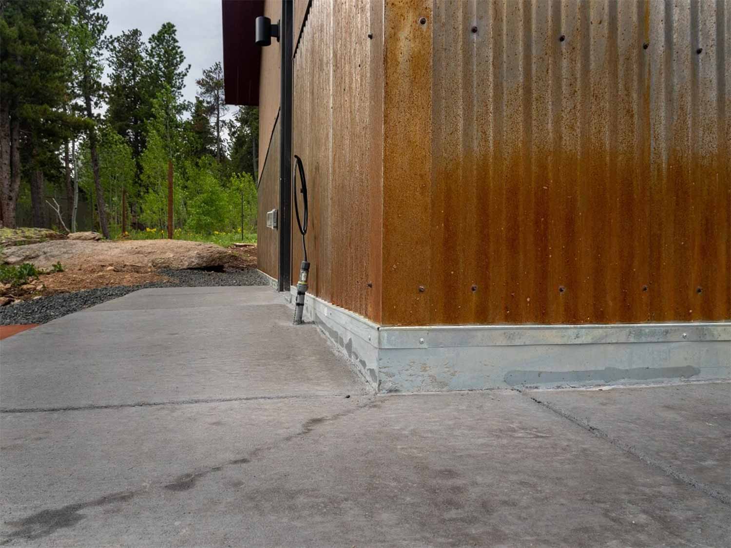 metal flashing at base of wall with corrugated metal higher up wall for extra protection