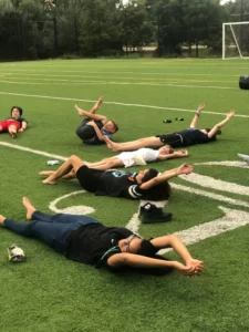 teens stretching on a soccer field