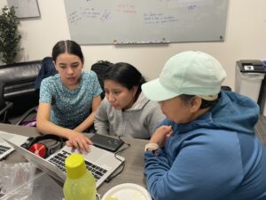 students and adult looking at computer